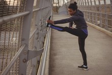 Woman Exercising On Bridge