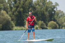 Man Enjoying A Ride On The Lake With Paddleboard