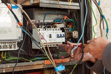 Repair Of Old Electrical Switchgear. An Electrician Replaces Old Electrical Wiring Devices.