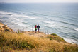 Pacific ocean coast. Cliffs. Flower and plant in the spring. Two people on the cliff