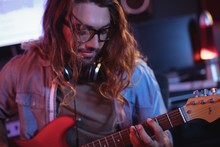 Close-up Of Male Audio Engineer Playing Electric Guitar