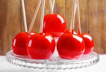 Sticker - Delicious holiday apples on glass cake stand against wooden background