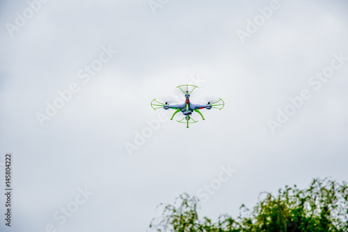 Fotografía white droid flying with a cloudy background