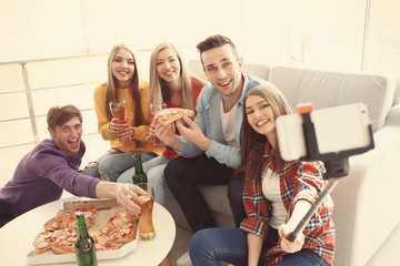 Wall Mural - Friends taking selfie while eating pizza at home party