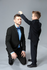 Sticker - Father and son dressed in suits on color background