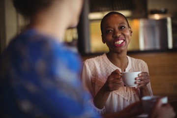 Wall Mural - Happy friends interacting while having coffee