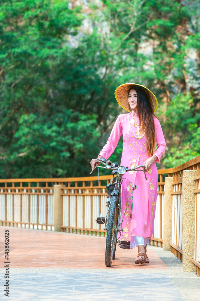 Portrait of Vietnamese girl traditional dress, Ao dai is famous traditional  costume for woman in Vietnam.Beautiful young asian woman wearing Vietnamese  national costume with vintage bicycle Stock Photo | Adobe Stock