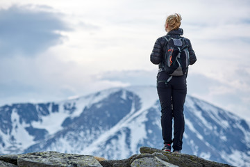 Woman hiker with backpack in the mountains