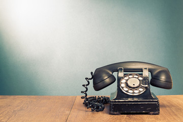 Fototapete - Retro black telephone on wooden table in front gradient background