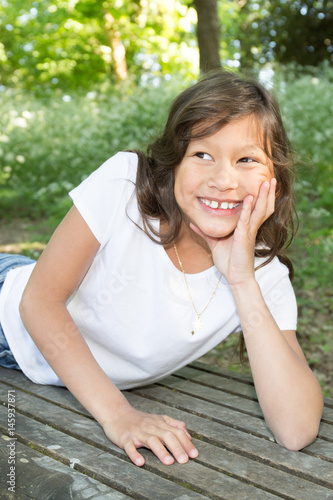 Pretty Young Mixed Girl With Curly Hairs Lying On The Bench Park