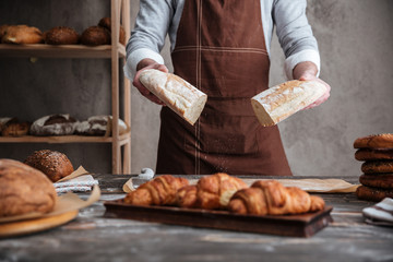 Sticker - Cropped photo of young man baker holding bread.