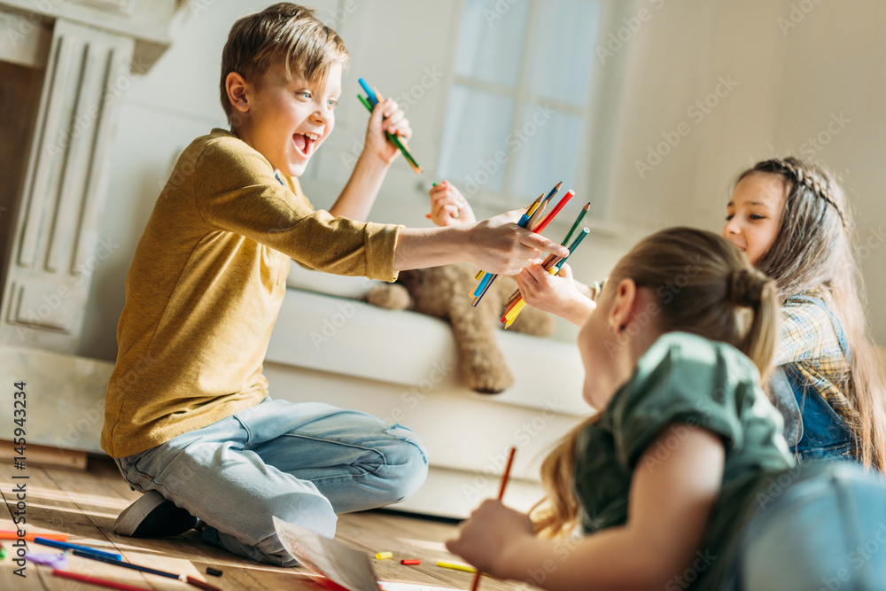 happy cute kids drawing on paper with pencils while sitting on floor ...