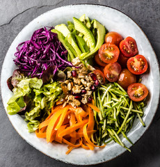 Bowl with vegetables and nuts. Vegan Buddha bowl on slate background