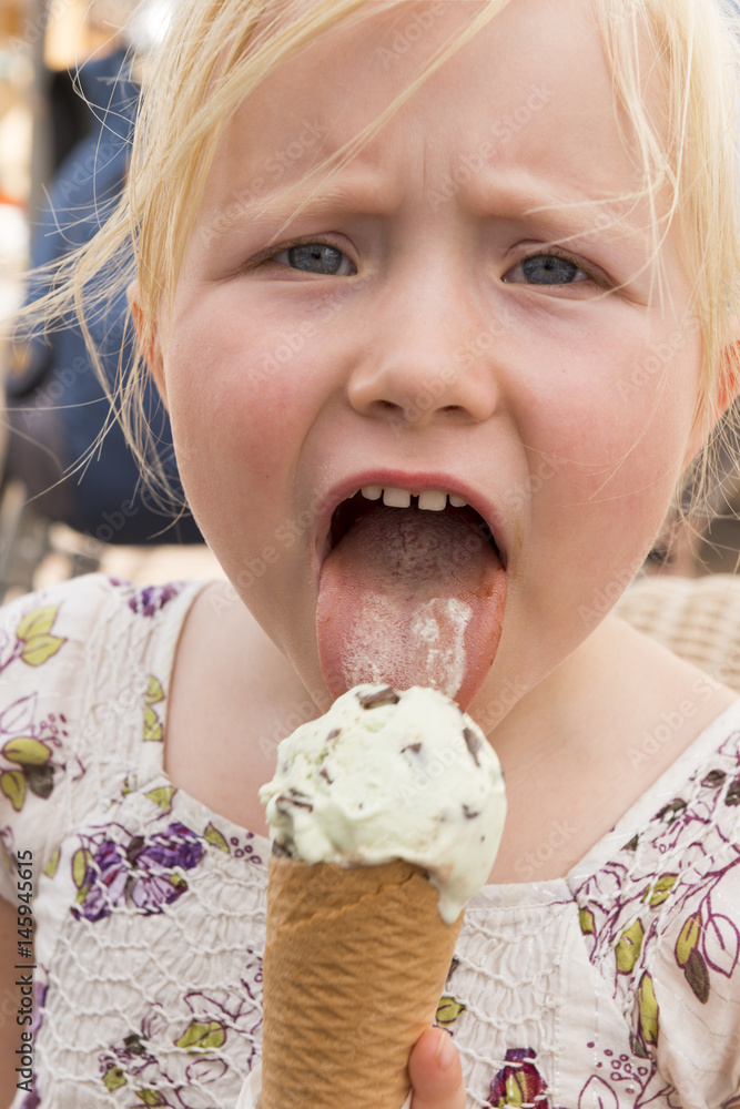 Little Girl Licking Ice Cream on Cone の Stock フォト | Adobe Stock
