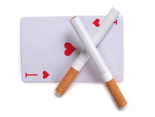 Cigarette with a filter and playing cards on a white background