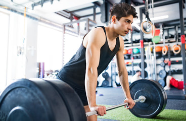 Sticker - Young fit hispanic man in gym lifting heavy barbell