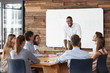 © Monkey Business - Young black man stands addressing colleagues at a meeting