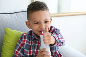 Wall Mural - Cute African American boy drinking yogurt at home