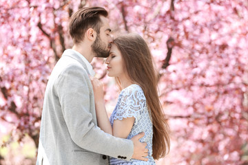 Canvas Print - Young lovely couple walking in spring park