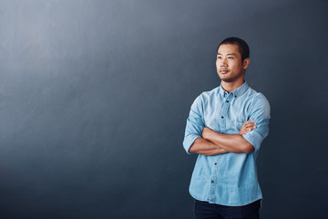 Sticker - Focused young Asian designer standing confidently in an office