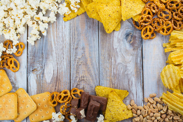 Unhealthy snacks on wooden background