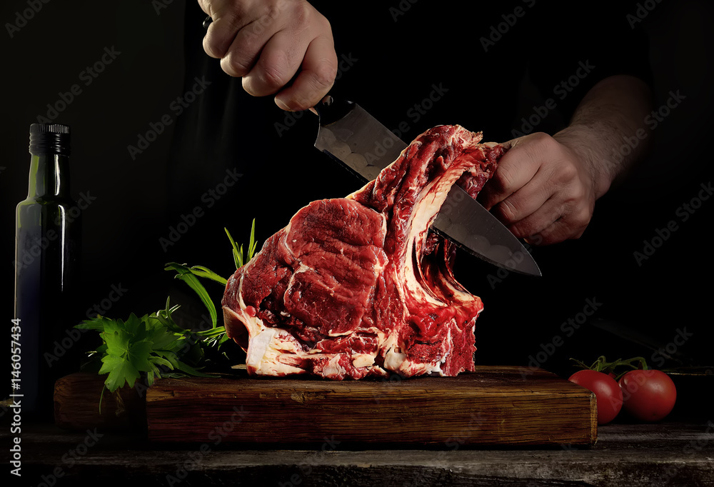 Man cutting raw beef meat. - obrazy, fototapety, plakaty 