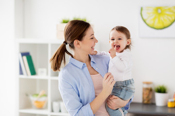 happy mother and little baby girl at home kitchen