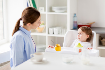 happy mother and baby having breakfast at home