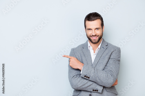 Fotomural Portrait of cheerful glad man in formal suit standing against gray background a
