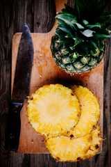 Wall Mural - Fresh raw organic pineapple on a wooden background