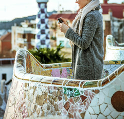 tourist woman at Guell Park viewing photos on camera