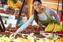 Young Attractive Fruit Market Saleswoman Selecting Fresh Fruit And Preparing For Working Day.