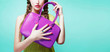Young girl holding her purple color handbag purse isolated on aqua blue background with copy space. 