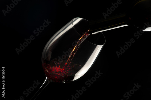Foto glass with red wine on black background