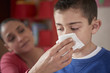 © Paco Navarro/Blend Images - Hispanic mother wiping nose of son with tissue