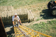 © Inti St Clair/Blend Images - Caucasian farmer climbing ladder to barn