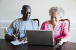 © Inti St Clair/Blend Images - Black couple using laptop and cell phone at table