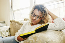 Smiling Mixed Race Woman Reading Book