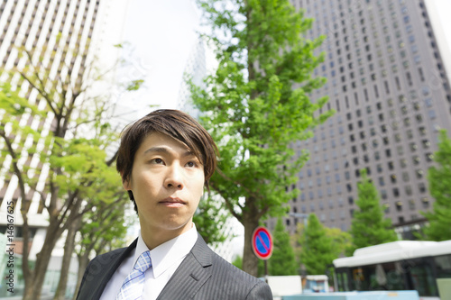 真剣な眼差しのビジネスマン 新宿ビジネス街背景 Adobe Stock でこのストック画像を購入して 類似の画像をさらに検索 Adobe Stock