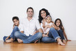 © PBNJ Productions/Blend Images - Portrait of smiling Mixed Race family sitting on floor