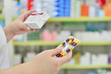 Wall Mural - Hand holding medicine capsule pack at the pharmacy drugstore.