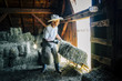 © Inti St Clair/Blend Images - Caucasian farmer in barn pulling bale of hay