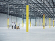 © Erik Isakson/Blend Images - Architects using blueprint in empty warehouse