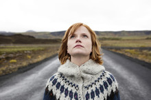 Caucasian Woman Wearing Sweater In Road Looking Up