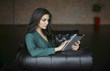 © Valeriya Tikhonova/Blend Images - Caucasian businesswoman sitting on sofa using digital tablet