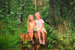 © viclin - Two little girl girl friends hugging in the forest on a sunny afternoon
