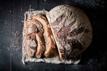 Tasty and fresh bread with whole grains on dark table