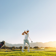 Wall Mural - Male golf player teeing-off with driver