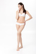 © Rychko Yevhen - beautiful young brunette woman with perfect sporty body in white lingerie on white background. Full length portrait