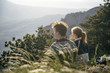 © Ivan Evgenyev/Blend Images - Caucasian couple sitting on hill admiring scenic view